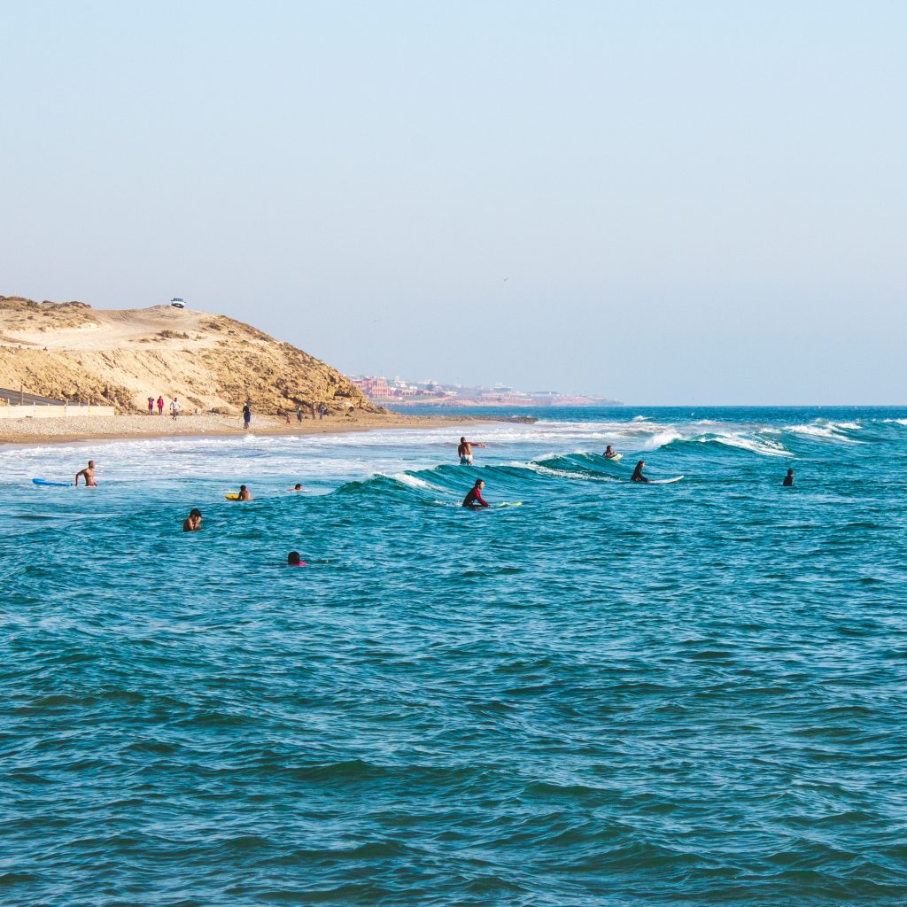 Nomade digital au Maroc : des surfers dans l'océan au bord de Tamraght.